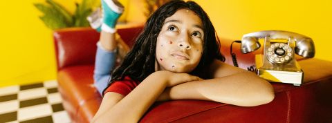 La tendance du flaking : pourquoi tout le monde se met à annuler à la dernière minute ? Une jeune fille sur son lit, un téléphone à ses côtés, les yeux levés vers le plafond, l'air blasé