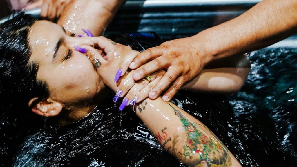 Une fille tatouée aux longs ongles violets se fait batiser
