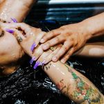 Une fille tatouée aux longs ongles violets se fait batiser
