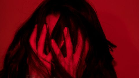 Une séance d’exorcisme à 562,50 Ğ1, ça vous dit ?  Sur fond rouge sang, une fille brune se tient la tête dans les mains,