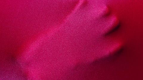 Une main derrière un tissu rouge fait son empreinte