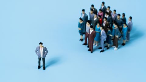 Une figurine masculine seule avec plus loin un groupe d'une quinzaine de figurines