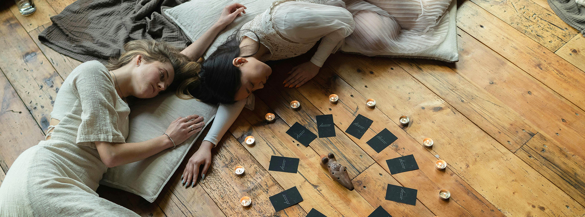 Fumigation à la sauge, acupuncture terrestre et nettoyage d'énergie : l'ésotérisme investit nos intérieurs - L'ADN Deux filles allongées dans une séance ésotérique