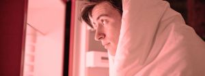 Un homme dans sa couetet regarde le contenu du frigo