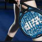 Les jambes d'une fille et d'un garçon : tous deux tiennent une raquette de paddel