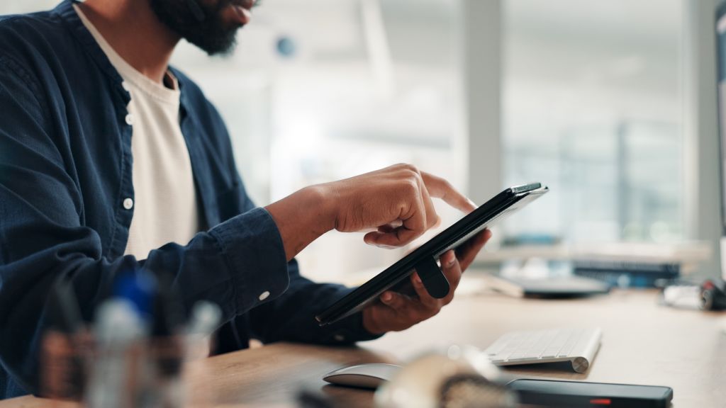 Businessman, hands and tablet in office for research, project planning and scroll on networking platform. Employee, tech and typing at desk for communication, email draft or browsing for productivity