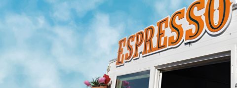 Des silhouettes attablées avec leurs cafés Une enseigne de coffeeshop