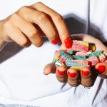 Close-up sur les mains d'une jeune femme pleines de bonbons
