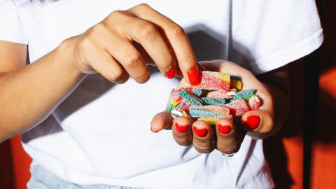 Close-up sur les mains d'une jeune femme pleines de bonbons