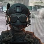 Un soldat avec un masque pour drone FPV tet derrière lui de la fumée