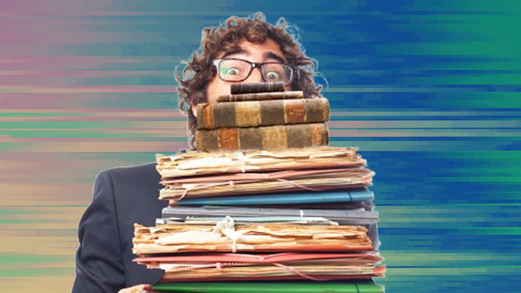 un homme avec plein de dossiers dans les bras