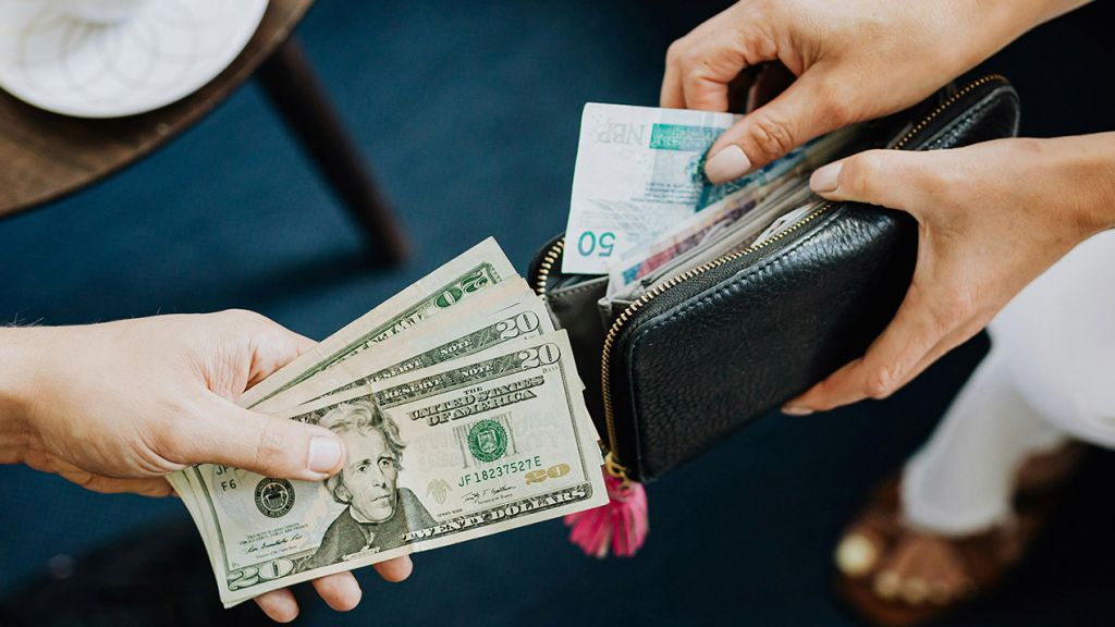 Des mains d'un homme et 'une femme ouvrant leurs portefeuilles