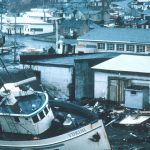 Vue d'une ville dévastée par une tempête avec des bateaux échoués et des maisons dévastées