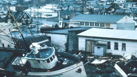 Vue d'une ville dévastée par une tempête avec des bateaux échoués et des maisons dévastées