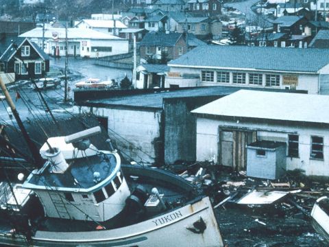 Vue d'une ville dévastée par une tempête avec des bateaux échoués et des maisons dévastées