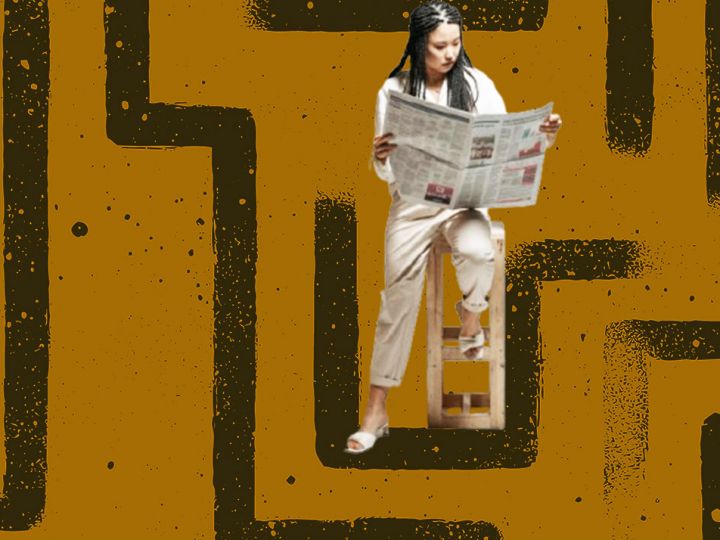 Une femme asiatique lit son journal avec un labyrinthe en fond