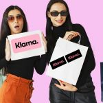 Deux femmes revenant de shopping avec plein de sacs et le logo Klarna
