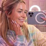 Une jeune femme influenceuse dans sa salle de bains emplie de produits de beauté