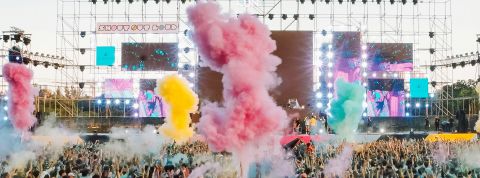 Les concerts sont-ils les derniers rituels collectifs ? Un concert en pmein air, avec fumigènes de couleurs et une foule de spectateurs