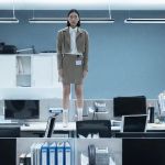 Une femme asiatique debout sur un bureau dans un open space