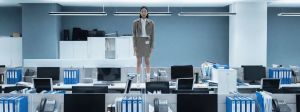Une femme asiatique debout sur un bureau dans un open space