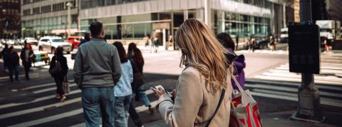 La « ville post-écran » : l'urbanisme face à l'invasion des smombies Une femme blonde de dos les yeux rivés sur son smartphone au passage piéton