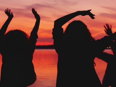 Des silhouettes d'hommes et femmes sur coucher de soleil