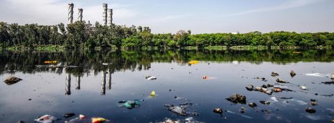 Un fleuve pollué avec des usines en fond