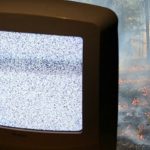 Un écran de TV qui grésille devant une forêt en feu