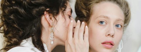 Une femme chuchotte à l'oreille d'une autre