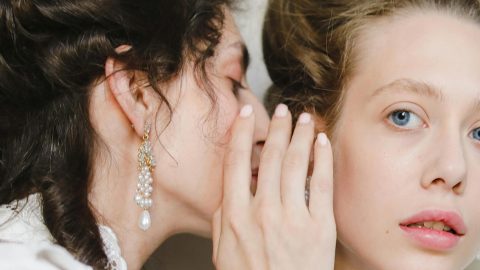Une femme chuchotte à l'oreille d'une autre