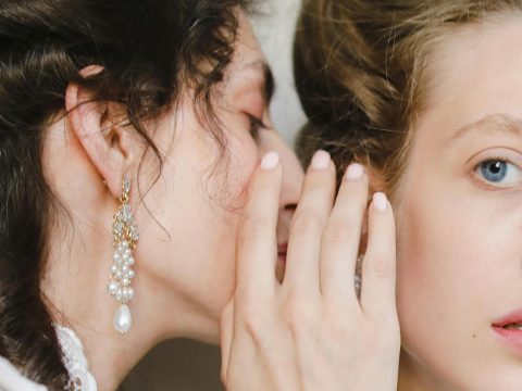Une femme chuchotte à l'oreille d'une autre