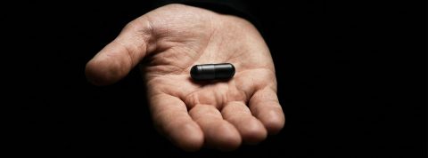 15-04-pilule-noire une main qui tend une pilule noire