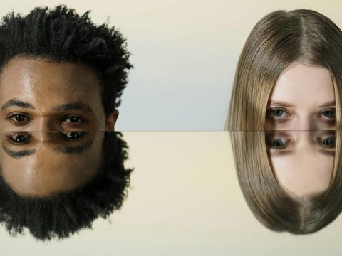 Un jeune homme à la peau mate, métis, et une jeune femme blonde avec les reflets du haut de leur visage dans un miroir horizontal