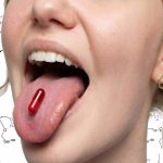Gros plan sur une bouche de jeune femme avec une gélule rouge sur la langue