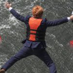 Un journaliste qui saute dans l'eau où flottent des logos YouTube