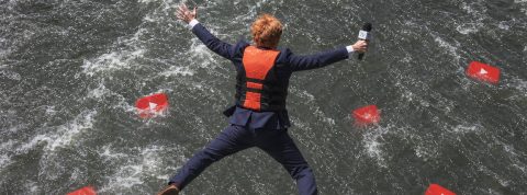 Ces journalistes TV qui tentent l’aventure sur YouTube Un journaliste qui saute dans l'eau où flottent des logos YouTube