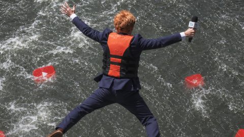 Un journaliste qui saute dans l'eau où flottent des logos YouTube