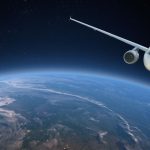 White passenger jet flying above Earth's curved horizon with a dark starry background.