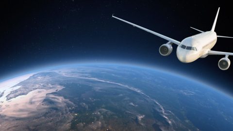 White passenger jet flying above Earth's curved horizon with a dark starry background.